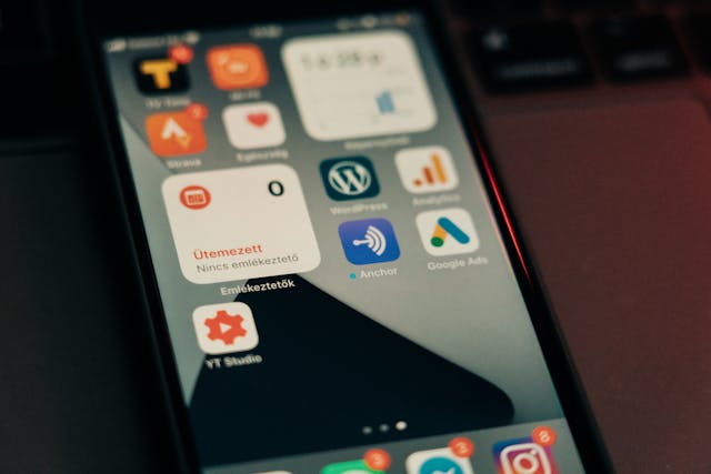 Young African business owner browsing a mobile-responsive website on a smartphone in a modern Lagos office, illustrating mobile-first web design.